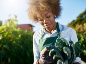 Black female farmer holding produce
